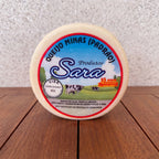 Round wheel of Queijo Minas Padrão from Produtos Sara on a wooden surface.